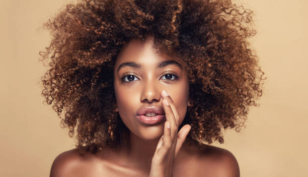 wanita muda berkulit coklat berbagi rahasia baru dengan kami. rambut afro alami dan padat di kepala model muda yang cantik. - rambut hitam alami potret stok, foto, & gambar bebas royalti