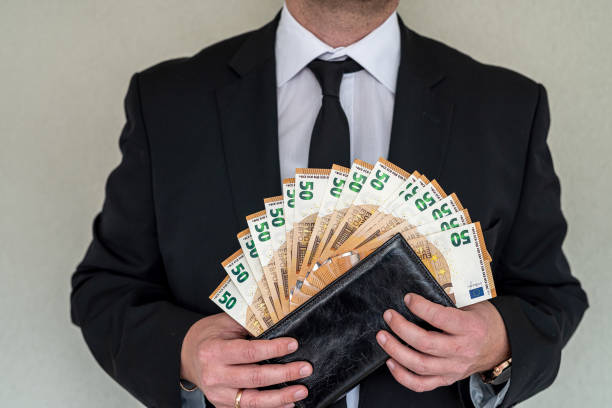 Young business man in a suit holding fan of euro banknotes stock photo