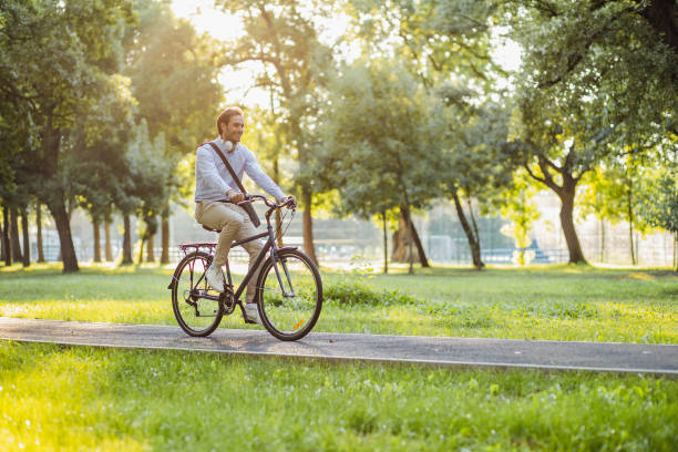 Young businessman uses a bicycle as a mode of transportation to work stock photo