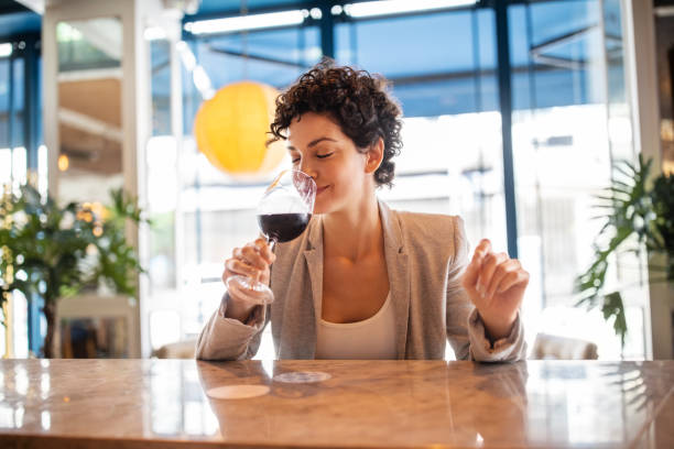young businesswoman enjoying wine at bar - sniffing glass imagens e fotografias de stock