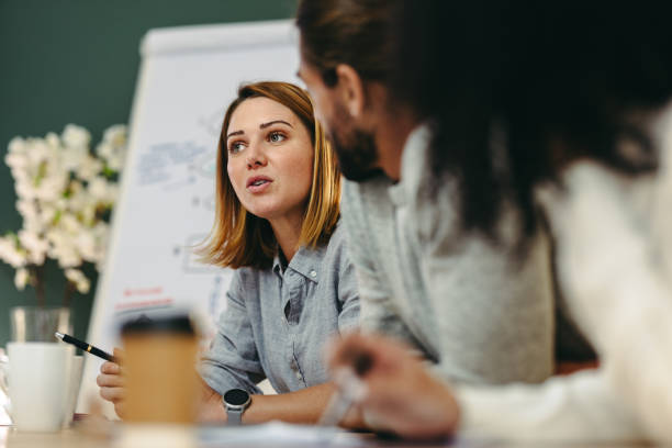 Young businesswoman having a discussion with her colleagues in a meeting stock photo