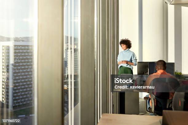 Young businesswoman looking at view from modern office
