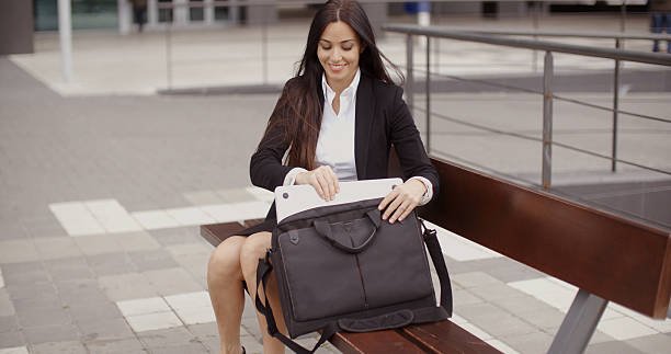 Young businesswoman placing her laptop in a bag stock photo