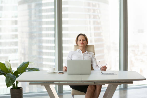 Joven empresaria relajándose apoyándose en una cómoda silla ergonómica en la oficina Joven empresaria relajándose apoyándose en una cómoda silla ergonómica en una moderna sala de oficina, un empleado tranquilo y feliz no siente alivio libre de estrés tomando un descanso para descansar del trabajo en la computadora respirando aire fresco silla ergonómica fotografías de archivo y fotos libres de derechos e imágenes