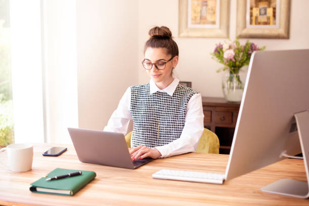 ung affärskvinna som använder laptop medan du arbetar sititng vid skrivbordet och arbetar - home office bildbanksfoton och bilder