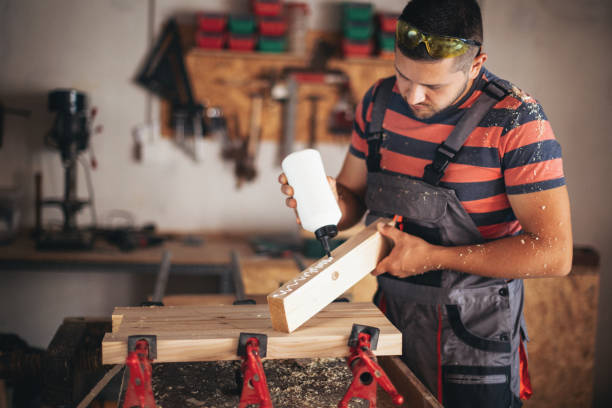 Young carpenter glueing wood stock photo