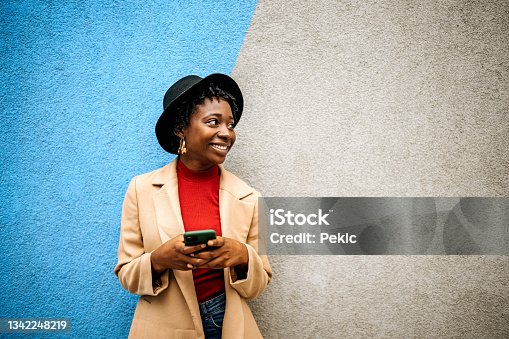 istock Young casually clothed woman posing in front of coloured wall 1342248219