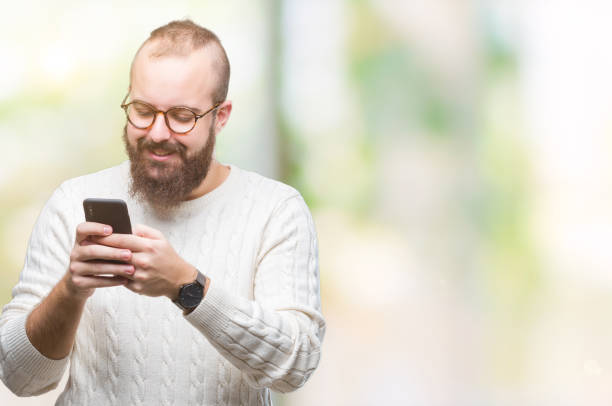 Young caucasian hipster man texting sending message using smartphone over isolated background with a happy face standing and smiling with a confident smile showing teeth  fat man looks at the phone stock pictures, royalty-free photos & images