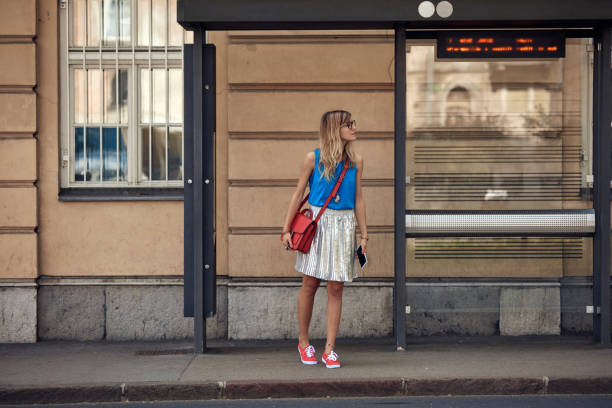 Young caucasian woman waiting for a public transportation on a station. stock photo
