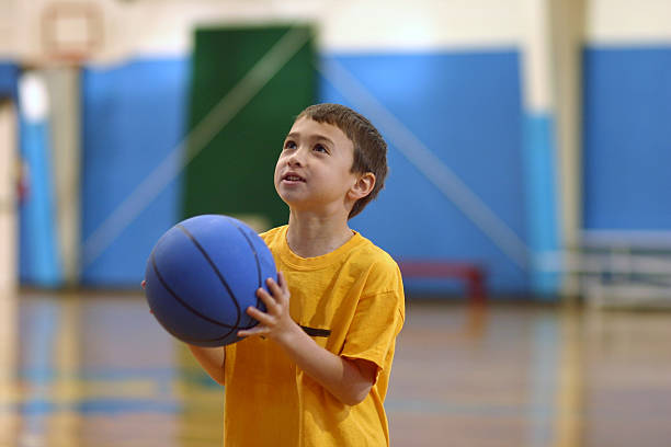 A young child holding a blue basketball stock photo