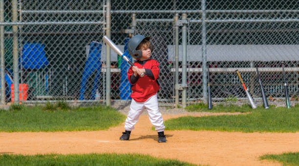 Young Child Playing Baseball A little boy stands at the plate awaiting the pitch during a baseball game. batting sports activity stock pictures, royalty-free photos & images