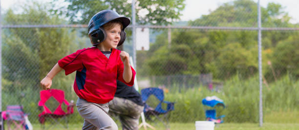 Young Child Running During a Baseball Game A young boy proudly running to first base after he hits the baseball. batting sports activity stock pictures, royalty-free photos & images