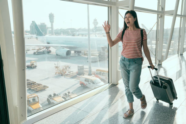 young chinese female student back to hometown young chinese female student back to home town country in hong kong airport waving hands to family pick her up. college girl cheerfully on holiday vacations. beautiful woman walk in hall with luggage wave goodbye asian stock pictures, royalty-free photos & images