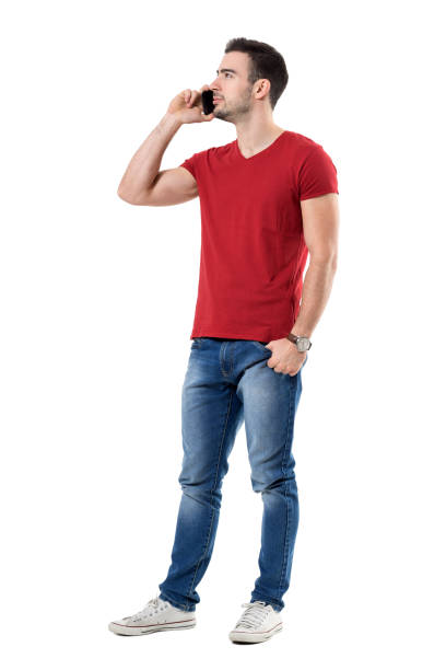 Young confident casual man talking on the mobile phone looking up Young confident casual man talking on the mobile phone looking up. Full body length portrait isolated over white studio background. cchaturbate stock pictures, royalty-free photos & images