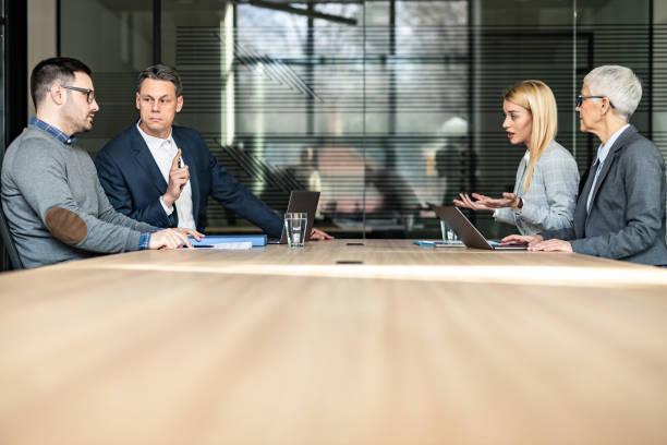 Young couple and their lawyers taking about separation in the office. Young couple and their lawyers talking about the divorce during a meeting in the office. Copy space. images of divorce stock pictures, royalty-free photos & images