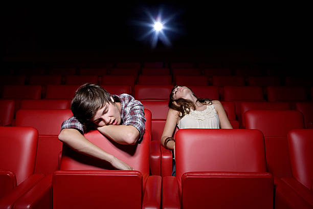 young couple asleep in the movie theater - boring date bildbanksfoton och bilder