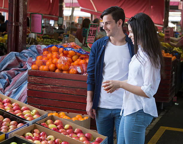 Young Couple at a Market Young couple shopping at a fruit market queen victoria market stock pictures, royalty-free photos & images