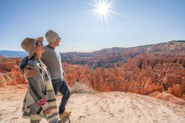 Young couple contemplating nature enjoying travel and adventure - America Young couple travel Bryce Canyon national park in Utah, United States, people travel explore nature. Couple hiking in red rock formations bryce canyon stock pictures, royalty-free photos & images
