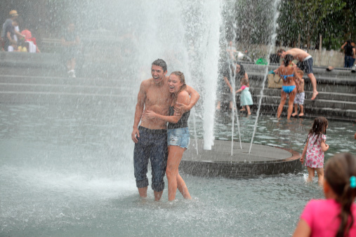 young-couple-cool-off-in-washington-square-park-fountain-nyc-picture-id459000641