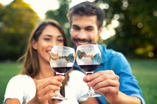 Young couple drinking wine on the summer picnic stock photo