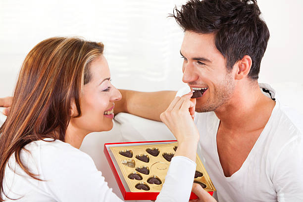 Young couple eating chocolate candies Young couple eating chocolate candies.SEE MORE WITH THESE MODELS: couple eating chocolate stock pictures, royalty-free photos & images