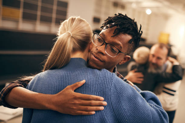 Young couple embracing each other Young African man in eyeglasses embracing the young woman and enjoying the process during therapy lesson group therapy stock pictures, royalty-free photos & images