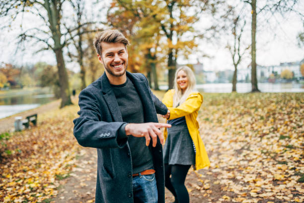 young couple having fun in autumn park stock photo
