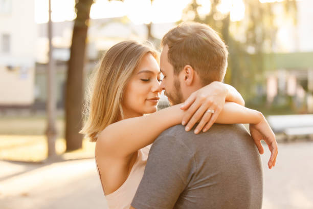 Young couple in love embracing in the city at sunset Young couple in love embracing in the city at sunset falling in love stock pictures, royalty-free photos & images