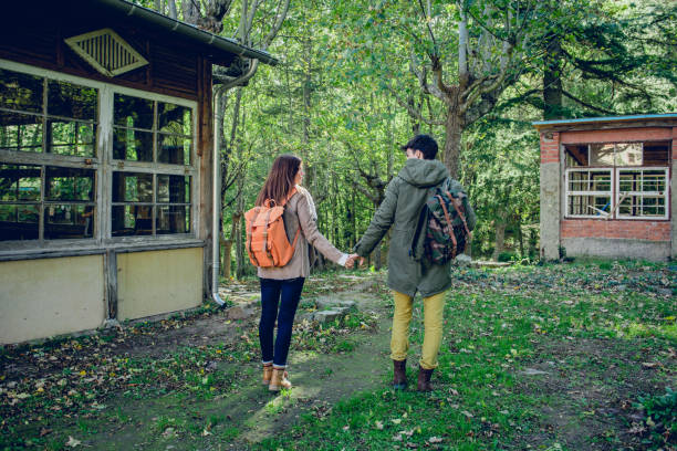 Young couple of hikers walking in the woods stock photo