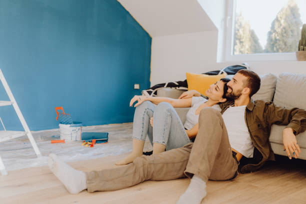 Young couple paint together a wall in their apartment stock photo