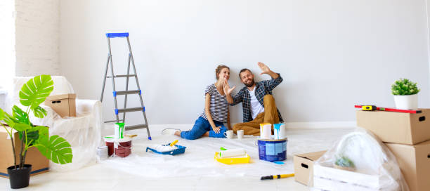 Young couple planning room interior Young couple woman and boyfriend pointing away  while sitting near white wall and planning room interior during renovation in new apartment home improvement stock pictures, royalty-free photos & images