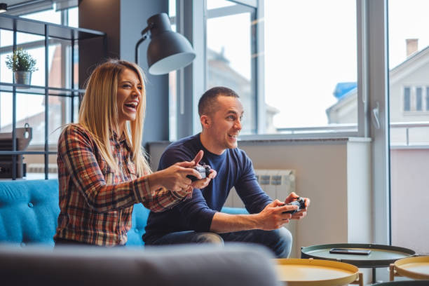 Young couple playing video games and smiling stock photo