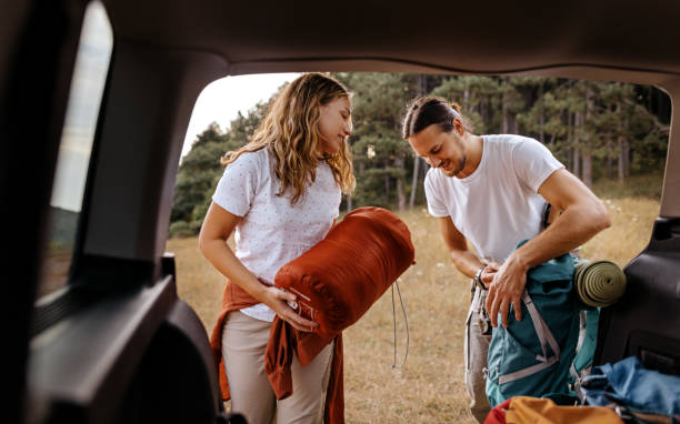 Young couple preparing gear for hike stock photo