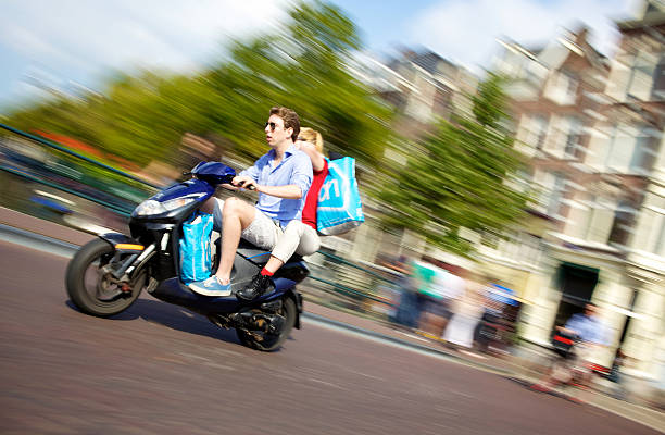 Young Couple Riding Scooter in Amsterdam stock photo