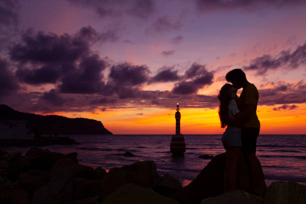 Young couple silhouette enjoying romantic colorful twilight. Valentines Day / honeymoon romantic date love concepts. stock photo