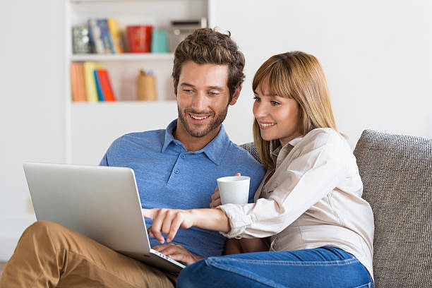 Young couple surfing on internet with laptop. stock photo