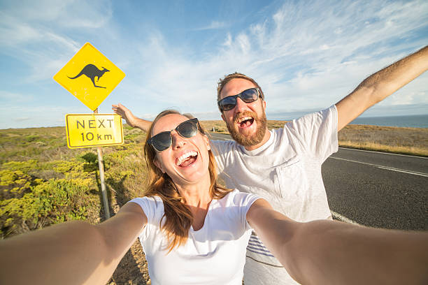Young couple take selfie portrait near kangaroo warning sign-Australia stock photo