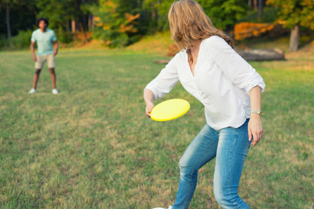 Young couple throwing disc in the nature stock photo