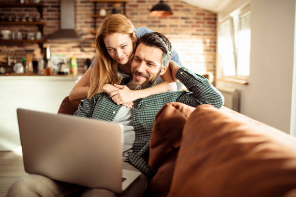 Young Couple using a Laptop at home stock photo