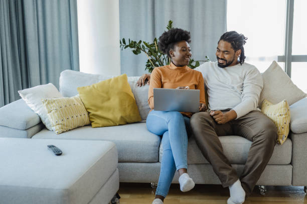 Young couple using laptop at home stock photo