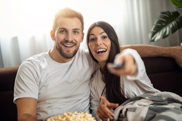 Young couple watching TV  at home stock photo