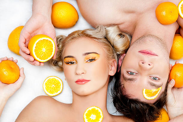 young couple with oranges stock photo