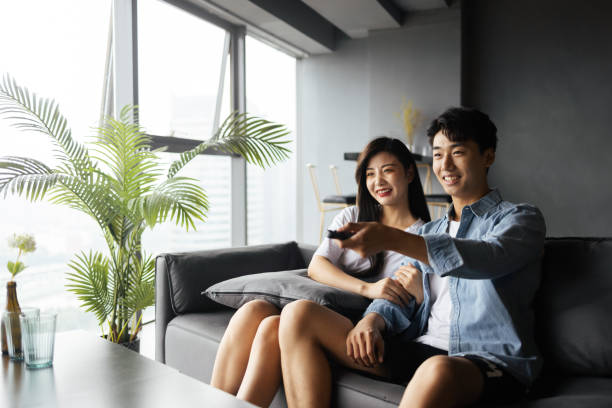 Young couples watch TV at home stock photo