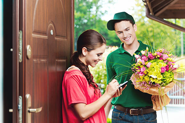 Young Delivery Man Delivering Flowers Stock Photo - Download Image ...