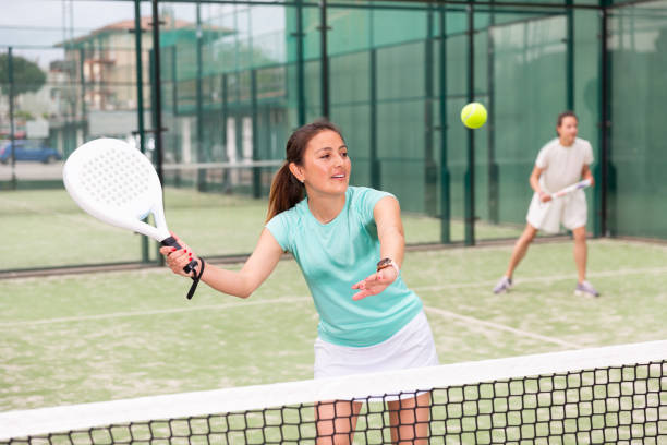 Young emotional women playing paddle tennis outdoors stock photo