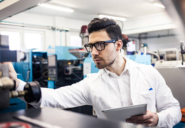 Young engineer holding digital tablet in the factory stock photo