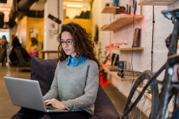 junge unternehmer weiblich bereitet eine präsentation auf einem laptop. - coworking stock-fotos und bilder