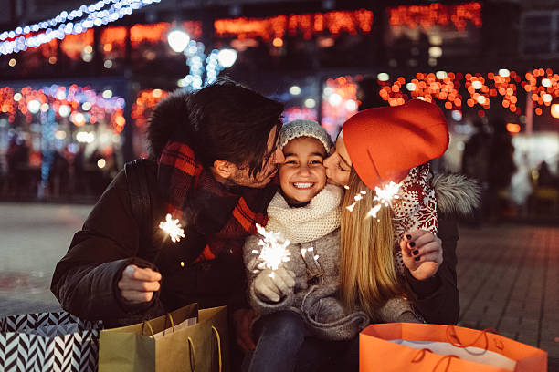 Young family celebrating Christmas Cute couple with sparklers wishing Happy new Year to the little daughter new years eve girl stock pictures, royalty-free photos & images