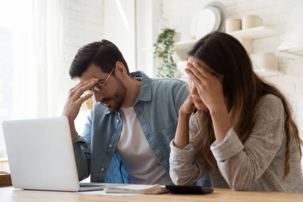 Young family couple feeling disappointed by high utility bills. Head shot stressed young family couple feeling disappointed by high utility bills, money loss. Unhappy nervous married spouse received debt mortgage notification, checking financial documents. disappointment stock pictures, royalty-free photos & images