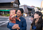 日本の伝統的な通りで「千葉」日本のせんべいを食べる若い家族